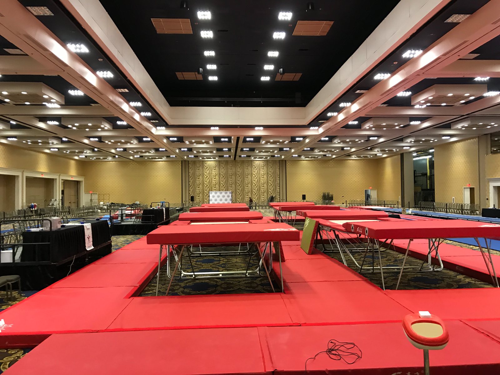 The Mega Meet competition floor at the Westgate ballroom, with rows of trampolines and red landing mats